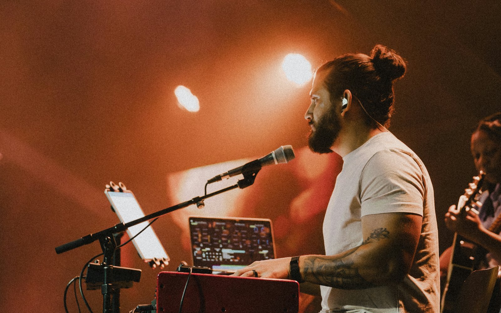 Penyanyi memainkan keyboard di depan mikrofon bersama gitaris saat live musik malam
